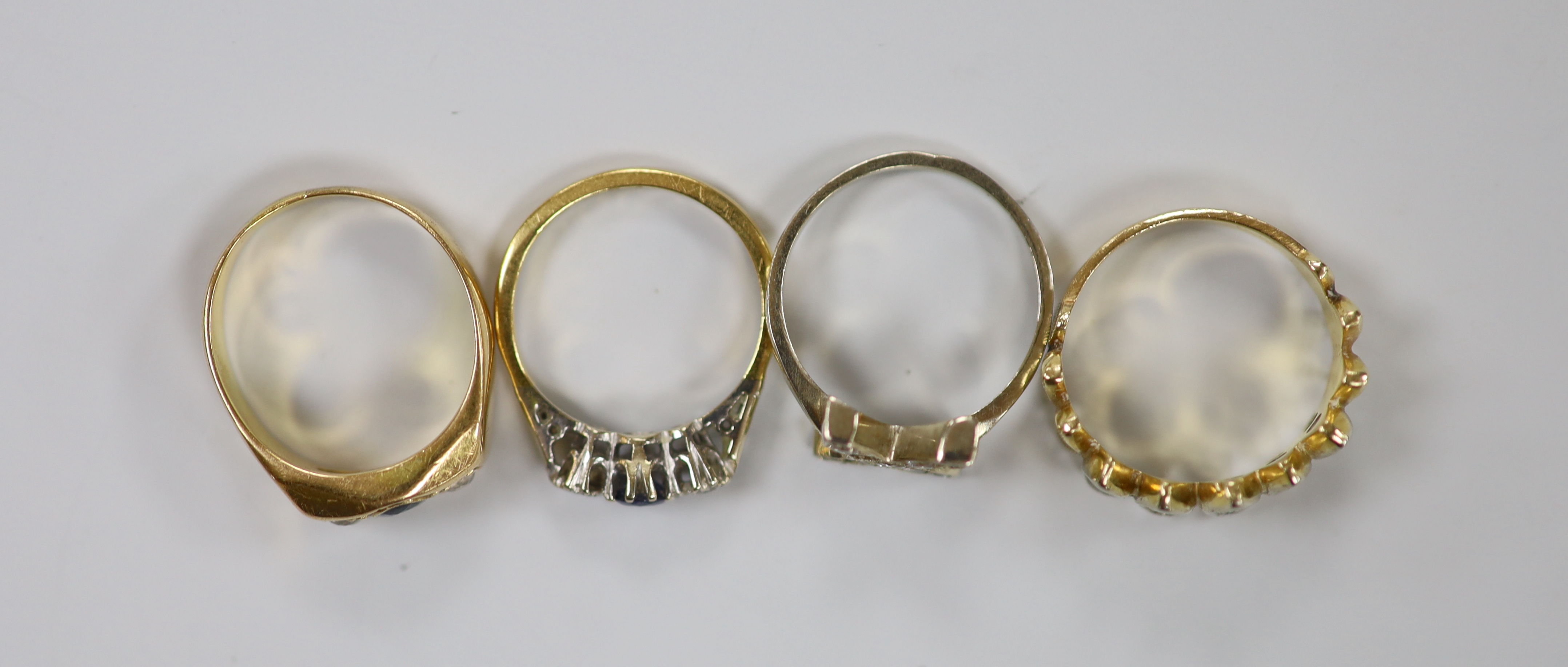 Two yellow metal, sapphire and diamond set three stone rings, one stamped 18ct, size K and two other yellow metal and diamond chip set cluster rings, gross weight 16.1 grams.